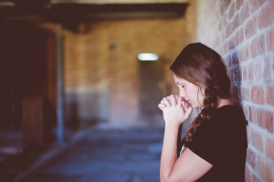 Frau betet mit geschlossenen Augen